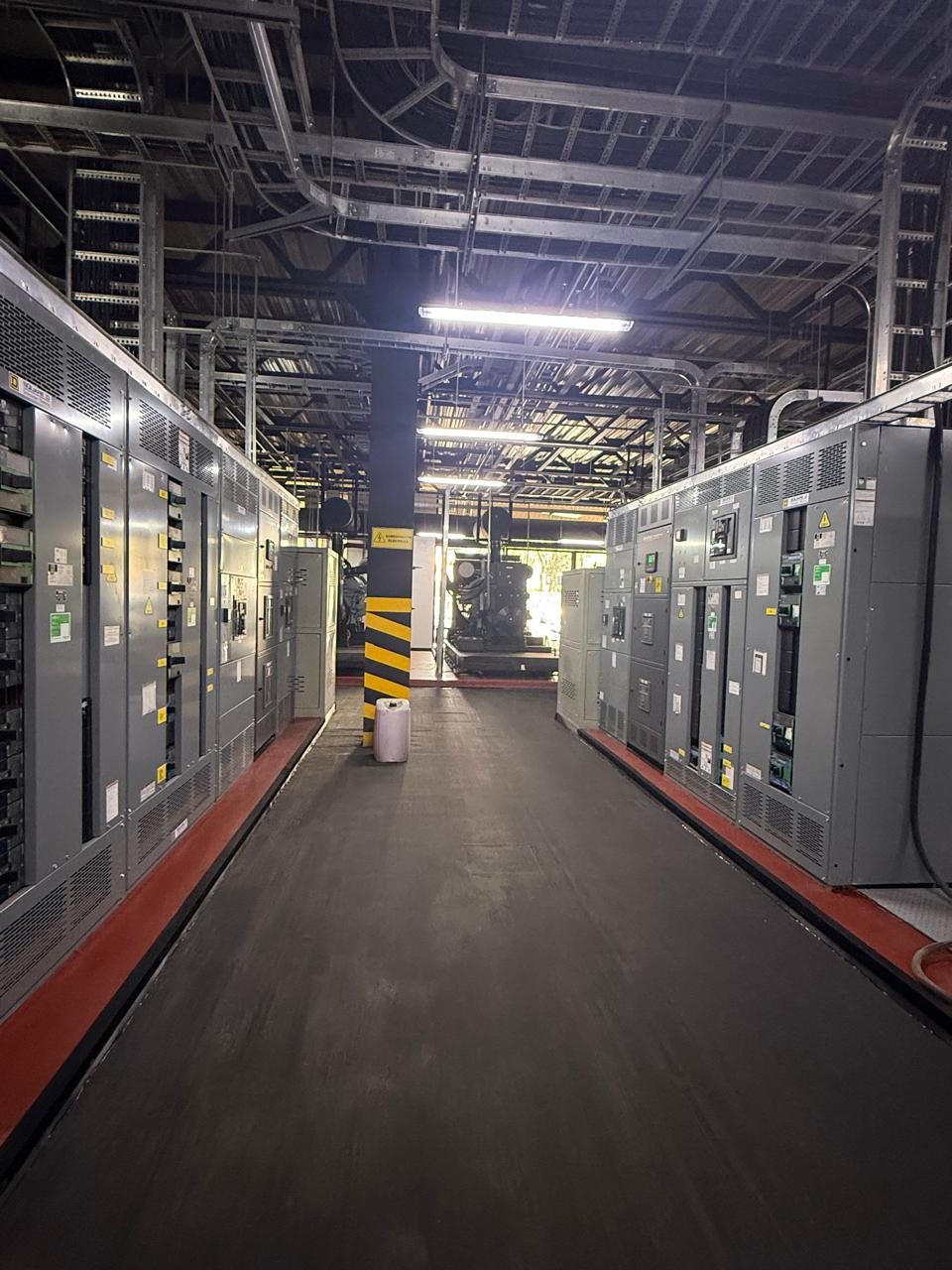Pasillo de un cuarto eléctrico con tableros de distribución a ambos lados