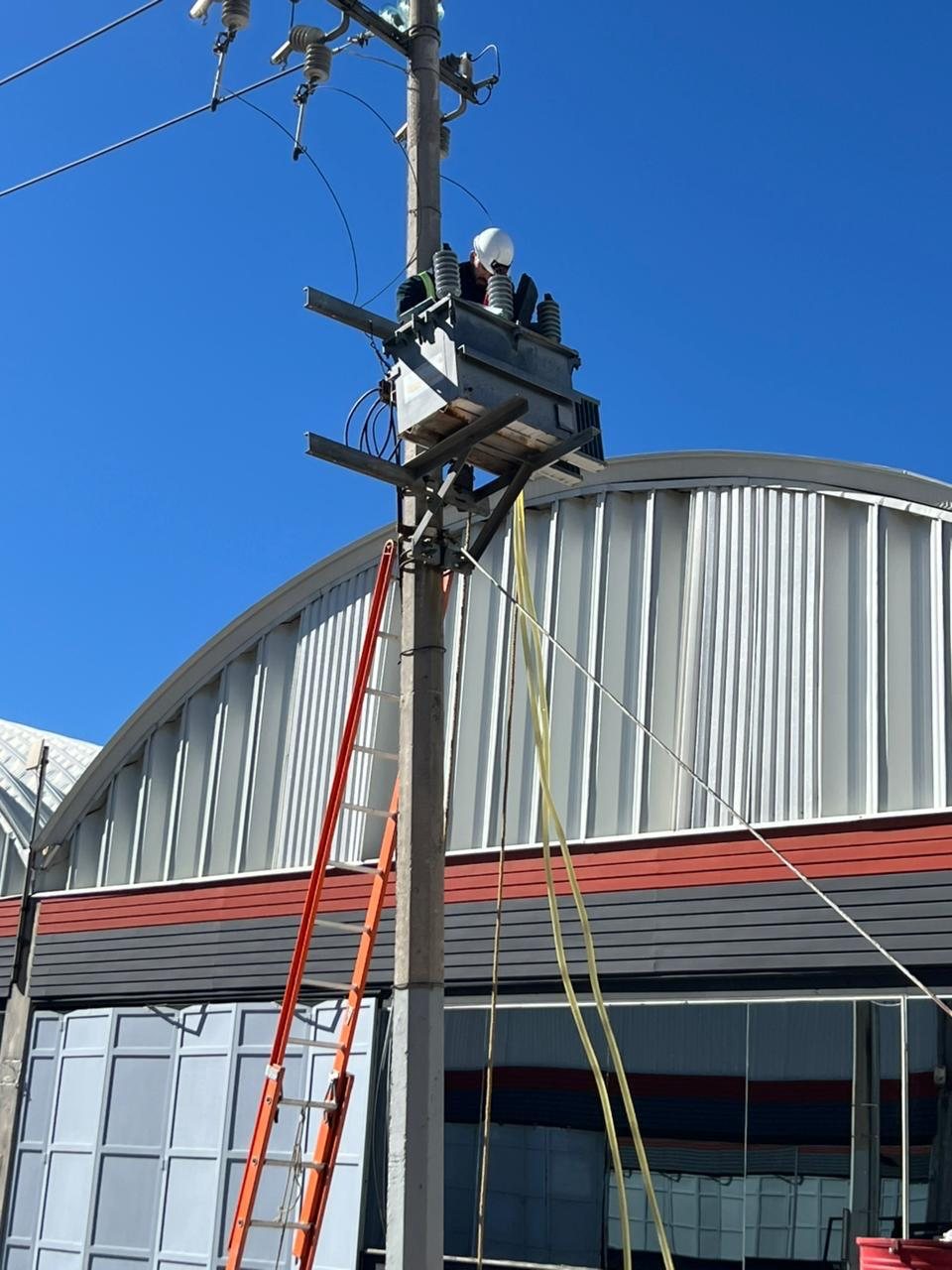 Técnico con casco trabajando sobre un transformador tipo poste